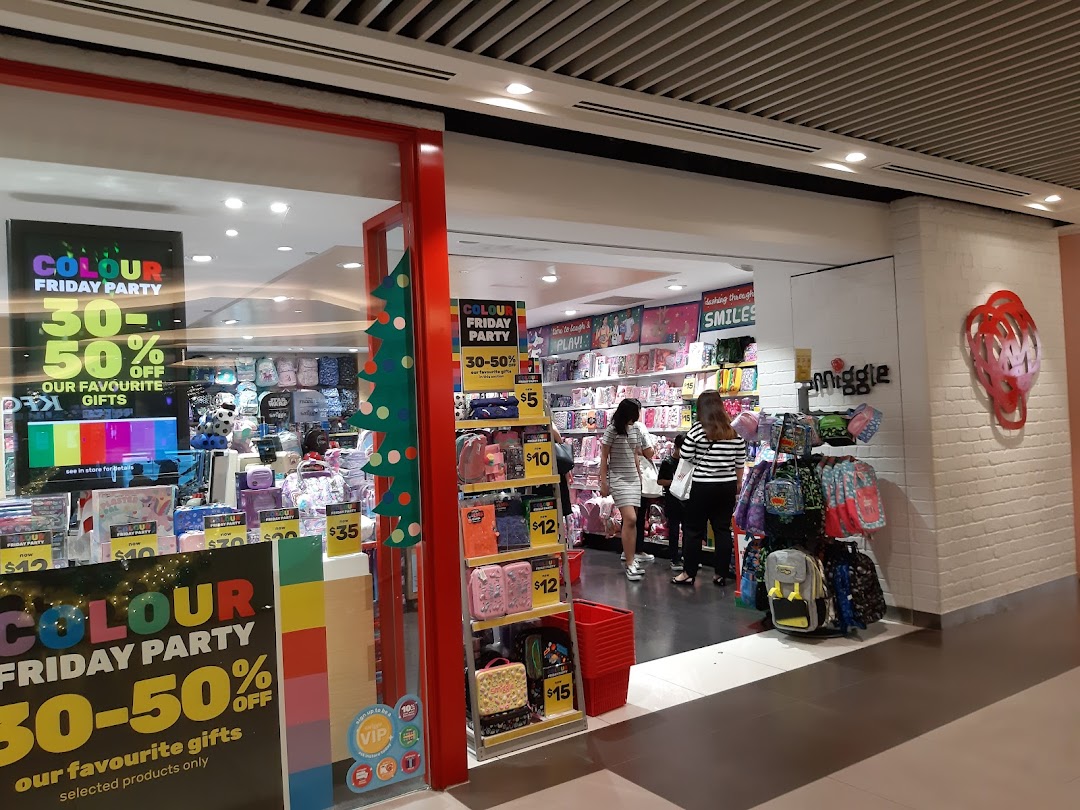 Smiggle shop front with colorful displays, promotional signs, and customers inside.