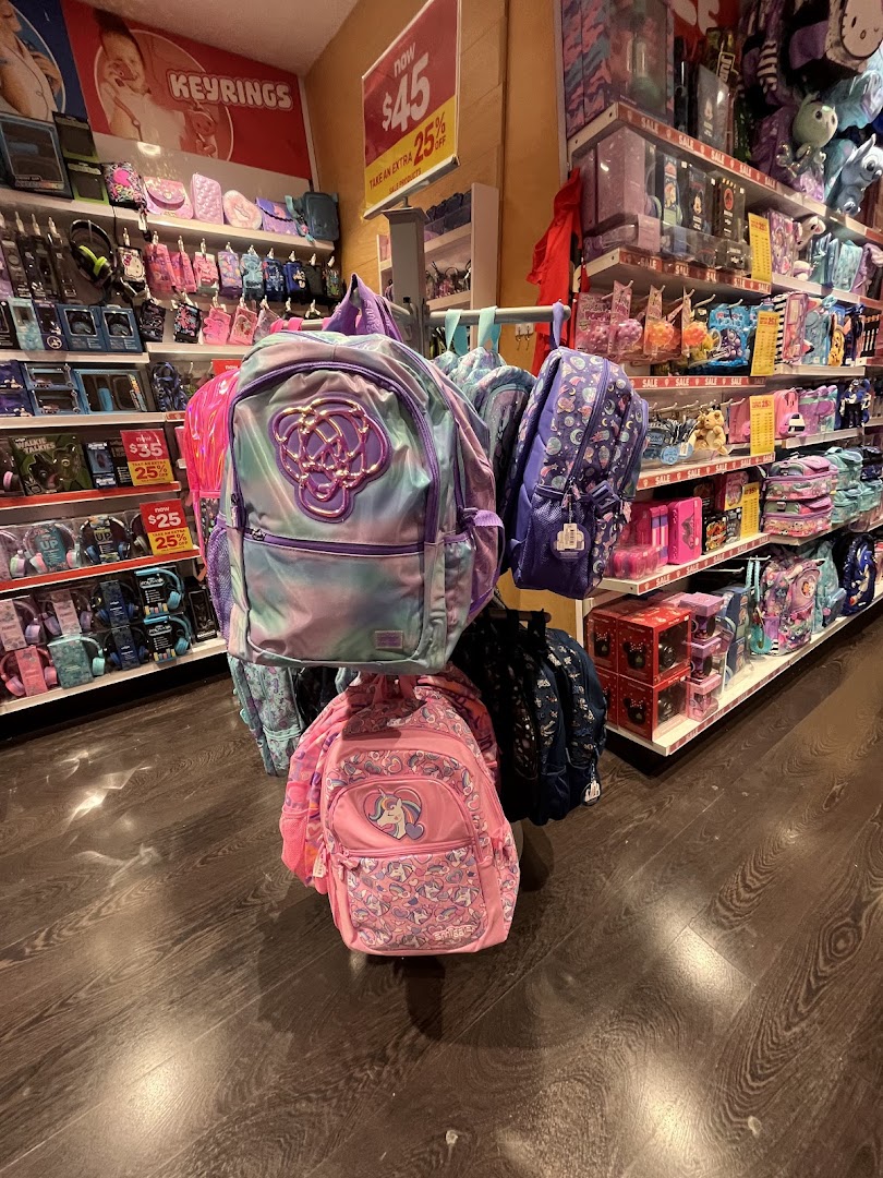 A vibrant display of colorful backpacks and various accessories inside a Smiggle store.
