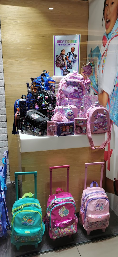 A vibrant Smiggle display featuring colorful backpacks, rolling bags, lunchboxes, and stationery items.