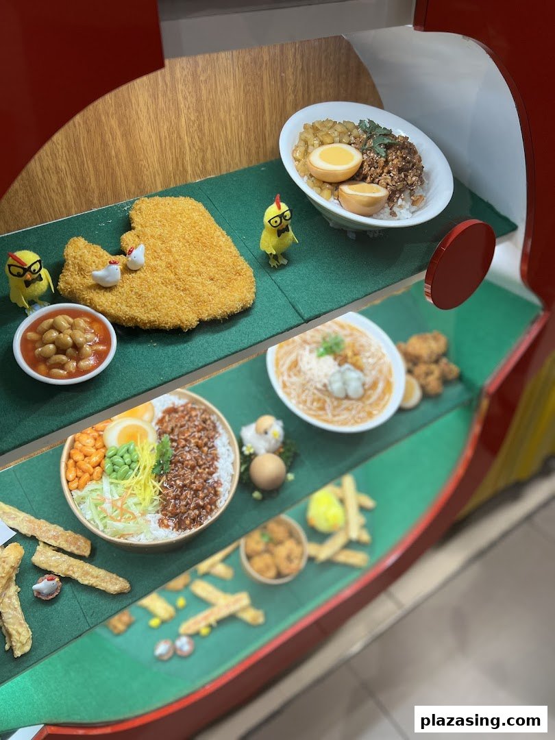 A vibrant display of food models featuring fried chicken, rice bowls, noodles, and cute chicken figurines.