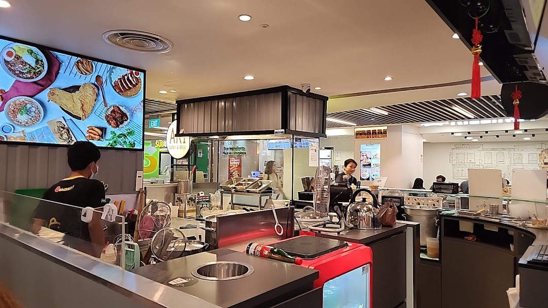 An interior view of Snackz it! food stall, featuring a service counter, staff, and a digital display showcasing food items.