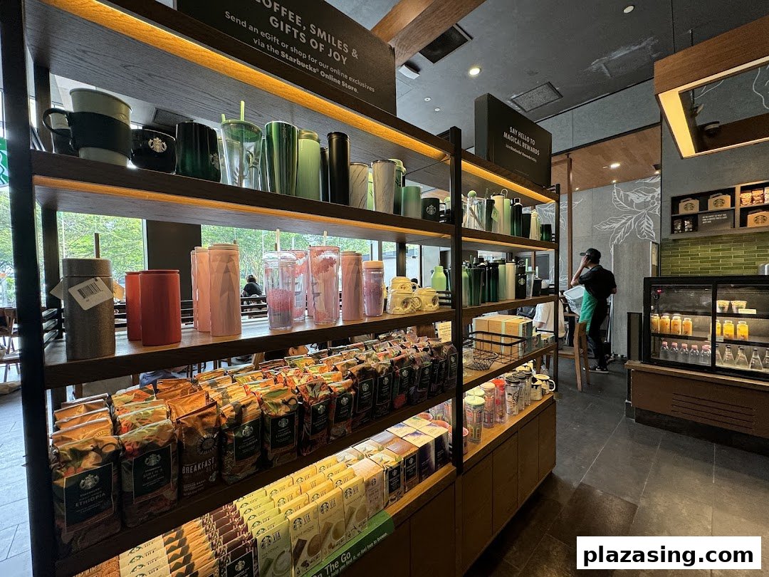 Interior view of Starbucks showcasing merchandise shelves with coffee beans, tumblers, and mugs.