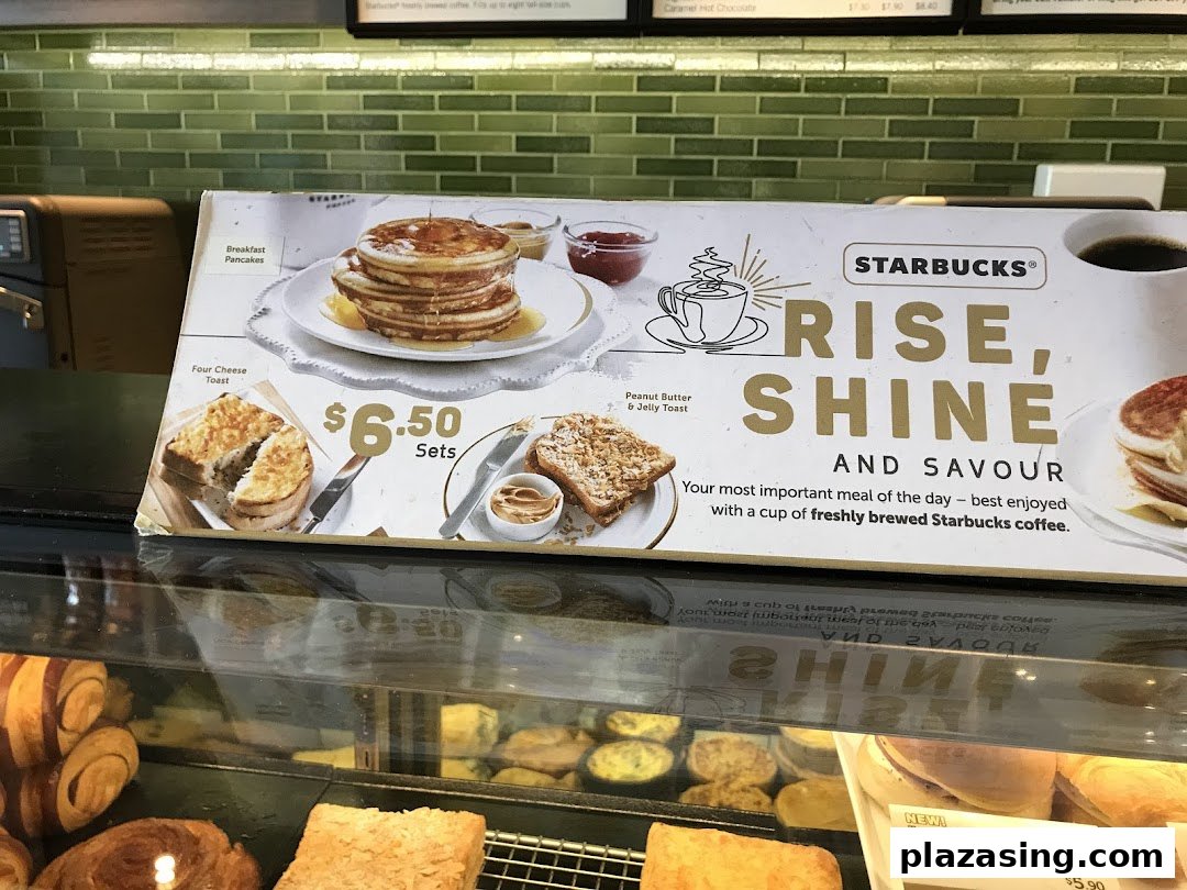 A Starbucks display board showcasing breakfast items and their prices, with a promotional message.