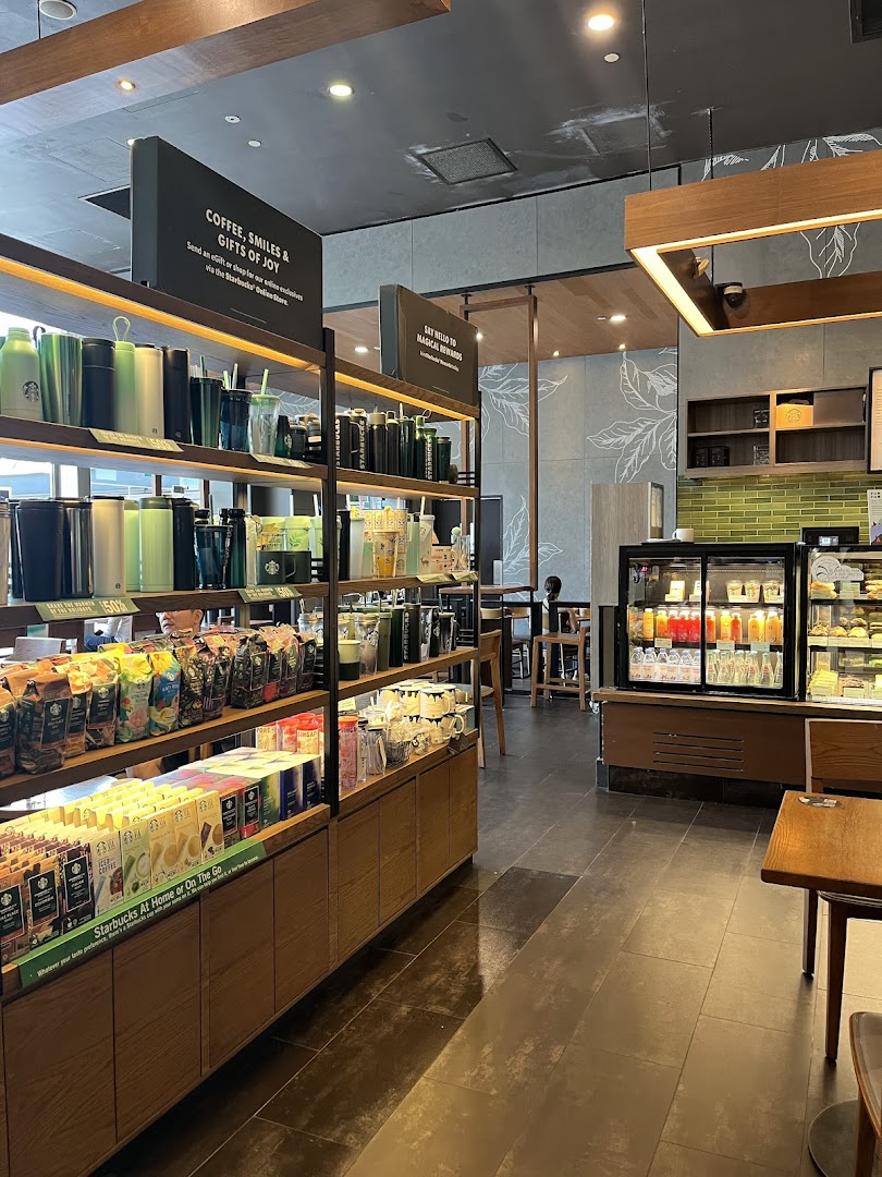 Interior view of Starbucks showcasing merchandise, coffee products, and a display of beverages and pastries.