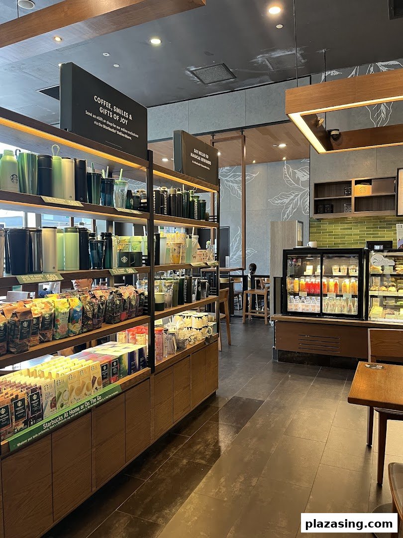Interior view of Starbucks showcasing merchandise, coffee products, and a display of beverages and pastries.