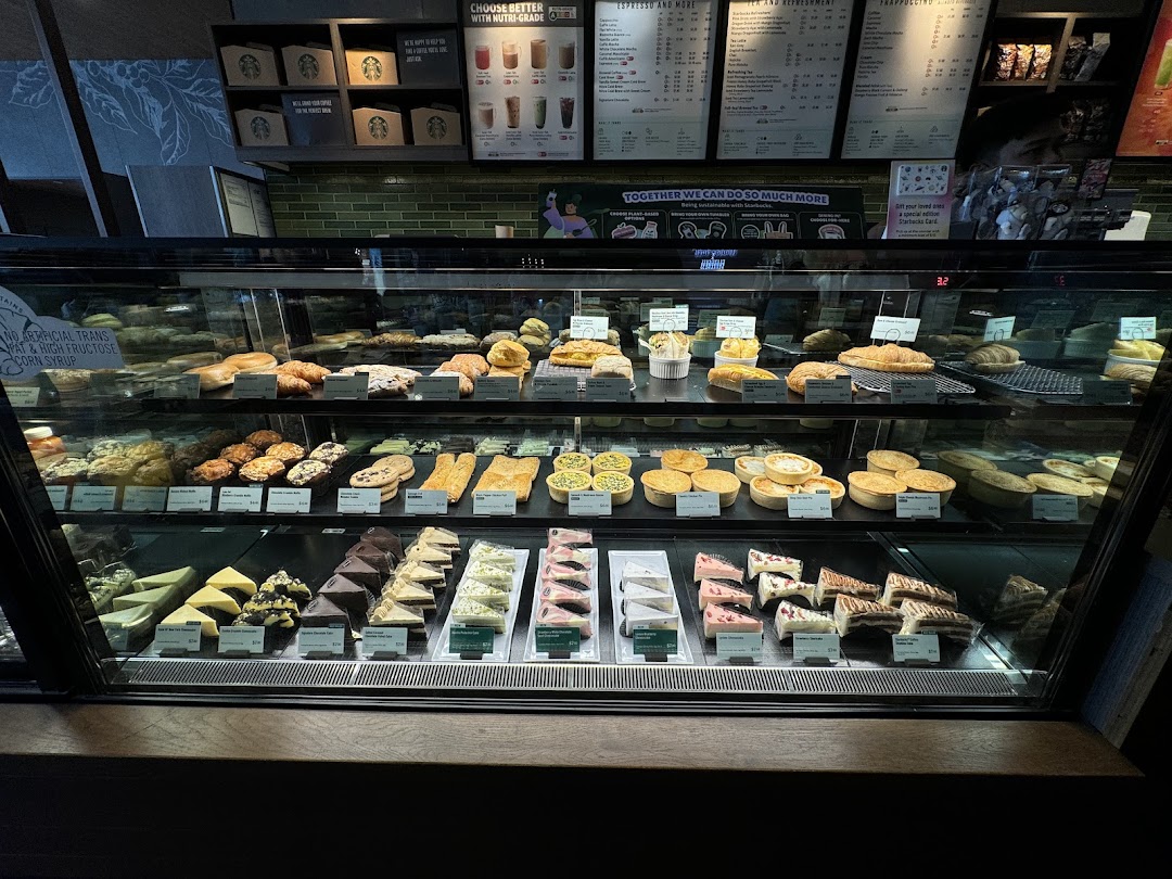 A vibrant display case showcasing a variety of pastries, cakes, and savory food items at Starbucks.
