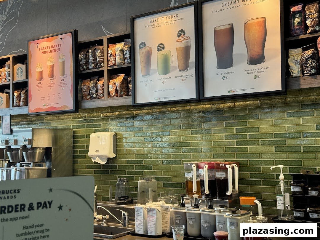 An interior view of Starbucks, showcasing the counter, menu boards, and coffee preparation area.