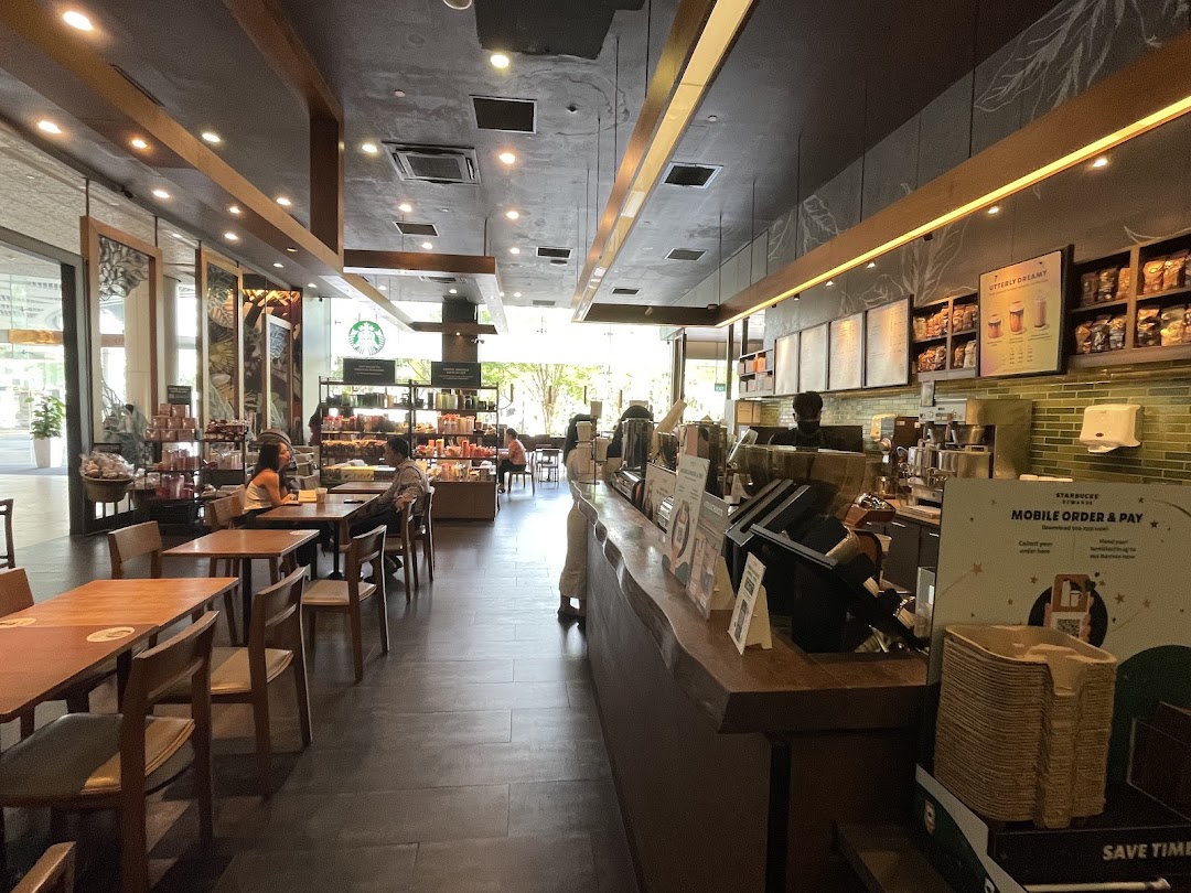 An inviting interior view of Starbucks Plaza Singapura, featuring the counter, seating area, and customers.