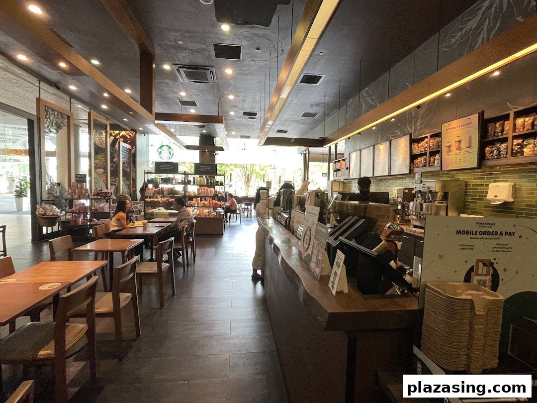 An inviting interior view of Starbucks Plaza Singapura, featuring the counter, seating area, and customers.