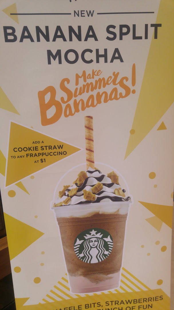 A Starbucks promotional poster featuring the new Banana Split Mocha Frappuccino and a cookie straw.