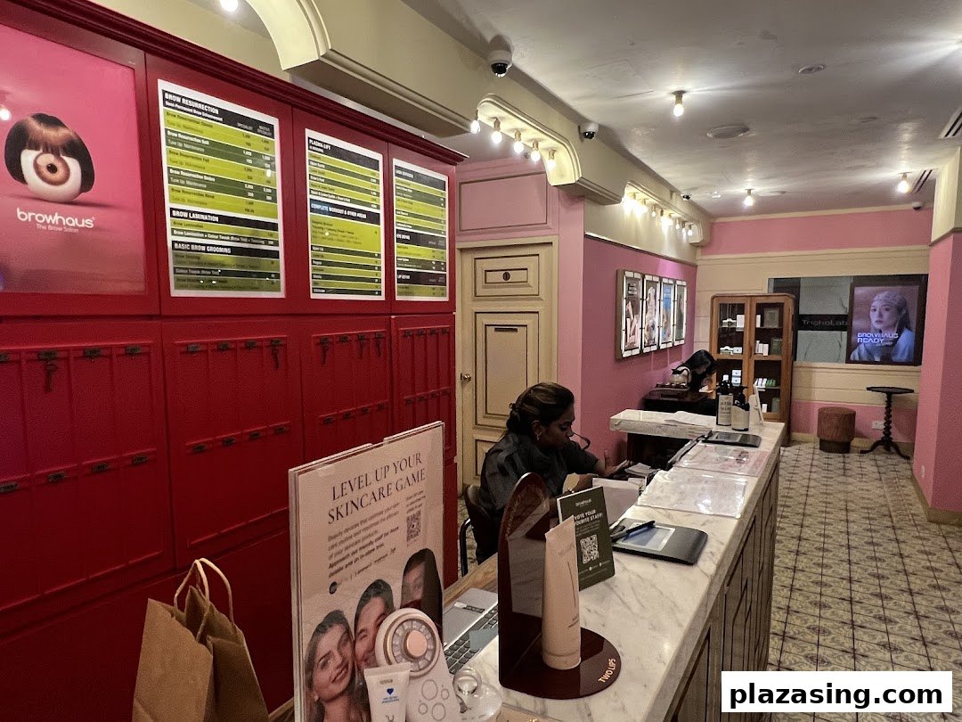 An interior view of Strip Co-Ed, featuring a reception desk, staff, and service menus for beauty treatments.