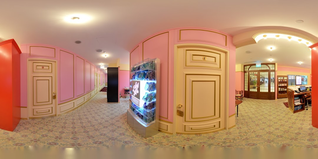 A vibrant pink and gold-themed interior hallway leading to treatment rooms and a reception area.