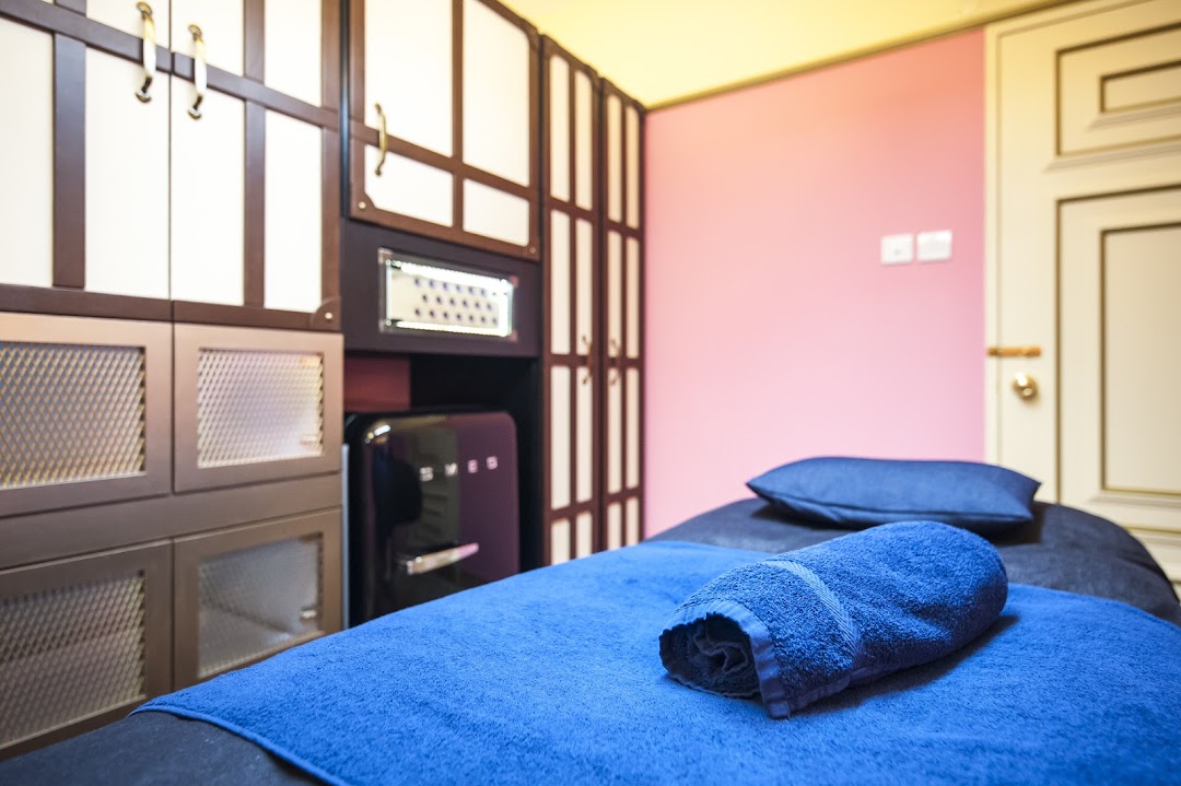 An interior view of a clean and inviting treatment room with a bed and blue towels.
