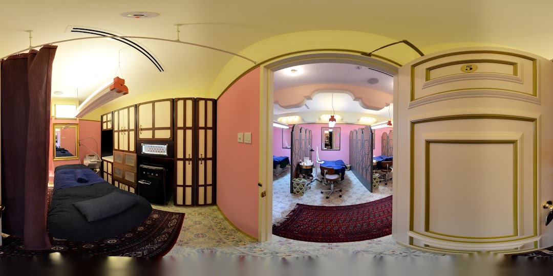 Interior view of Strip Co-Ed Plaza Singapura, showcasing private treatment rooms with beds and equipment.