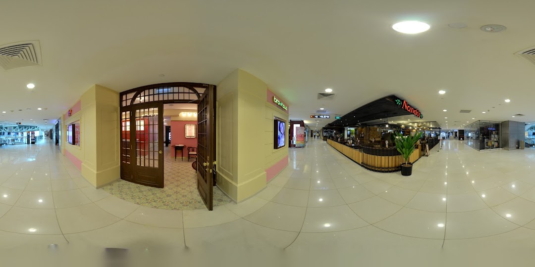 The elegant entrance of Strip Co-Ed, a beauty salon, within a brightly lit shopping mall corridor.