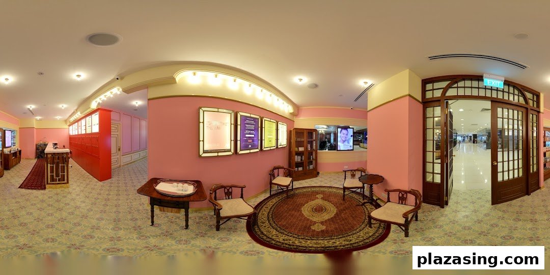 A panoramic view of Strip Co-Ed's elegant pink and gold interior with a waiting area and reception.