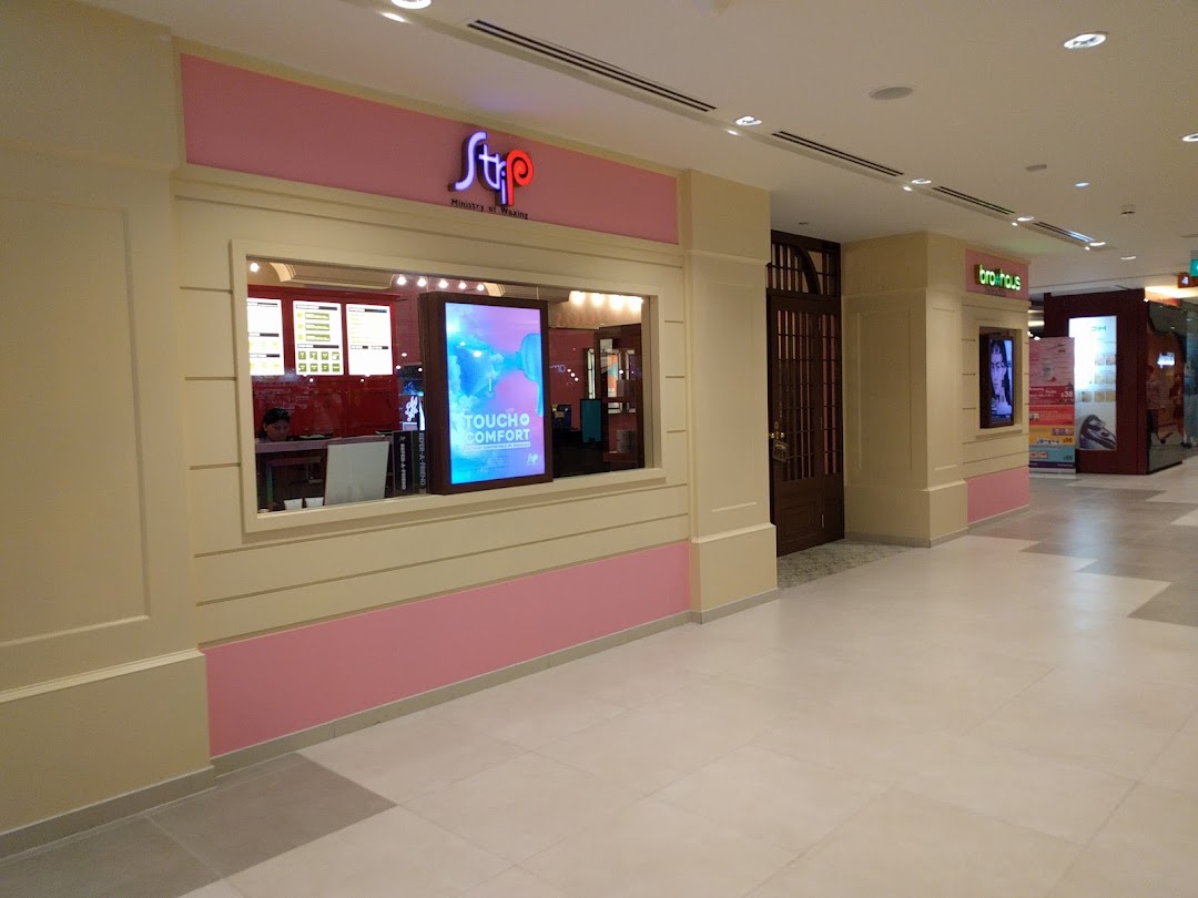 The image shows the pink and cream facade of Strip Co-Ed Plaza Singapura, a waxing salon, with its entrance and display window.