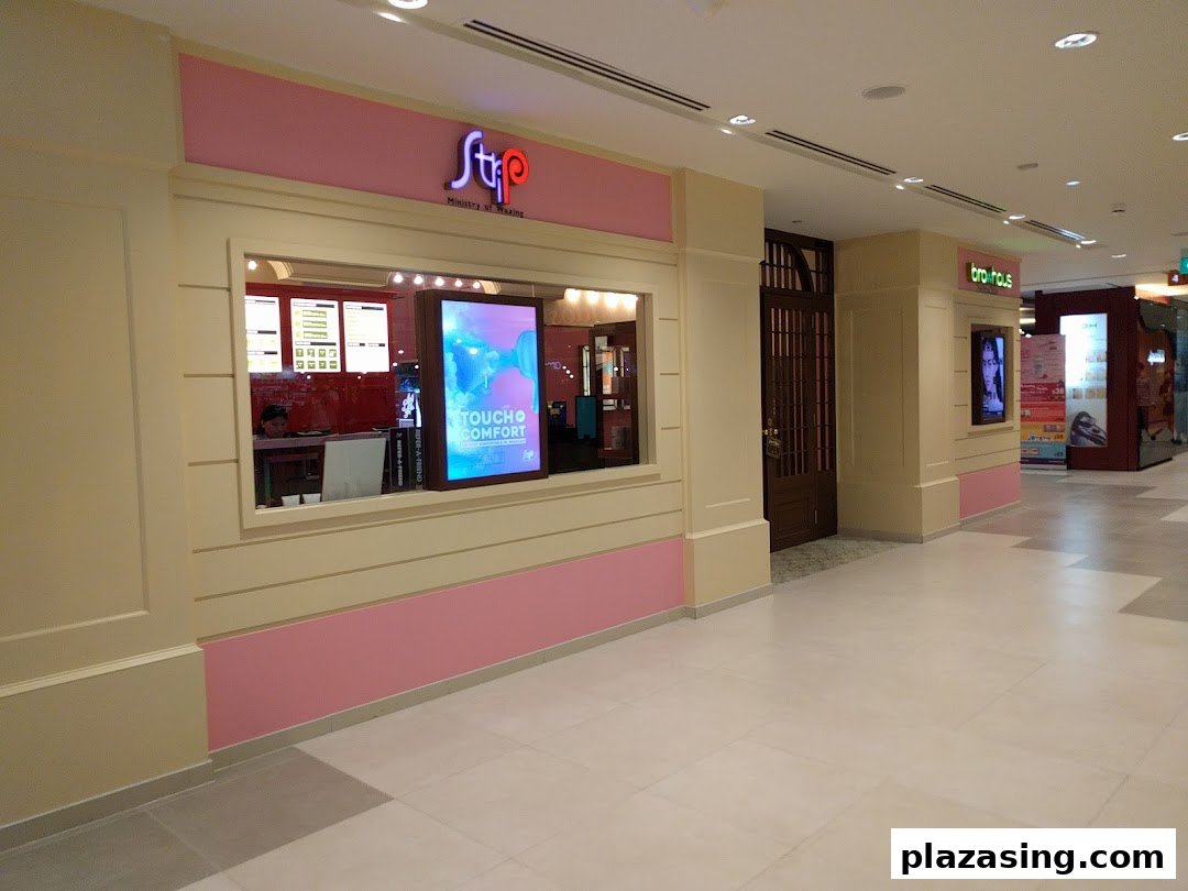 The image shows the pink and cream facade of Strip Co-Ed Plaza Singapura, a waxing salon, with its entrance and display window.