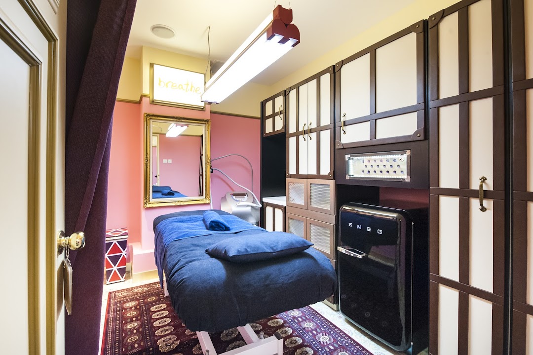 A private, well-appointed treatment room with a bed, modern equipment, and stylish storage.