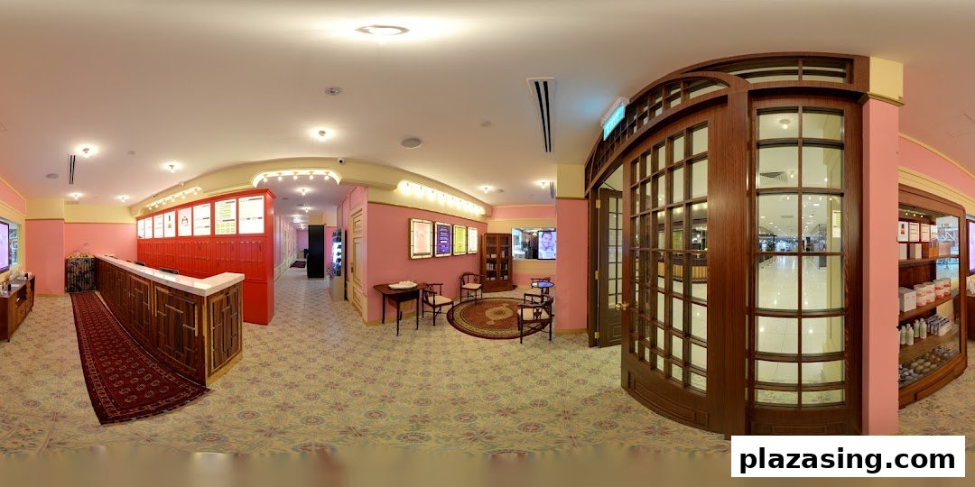 A vibrant pink-themed interior of Strip Co-Ed, featuring a reception desk, waiting area, and product displays.
