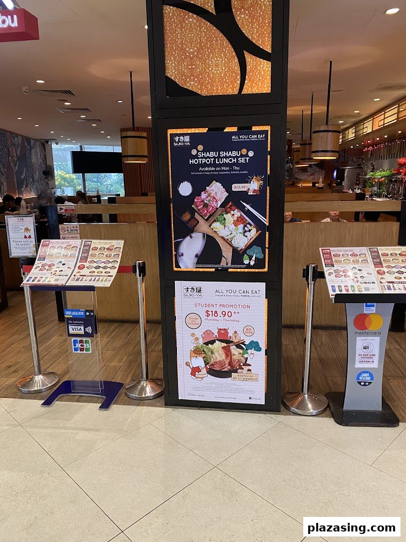 The entrance of Suki-Ya, an all-you-can-eat shabu-shabu restaurant, featuring promotional posters.