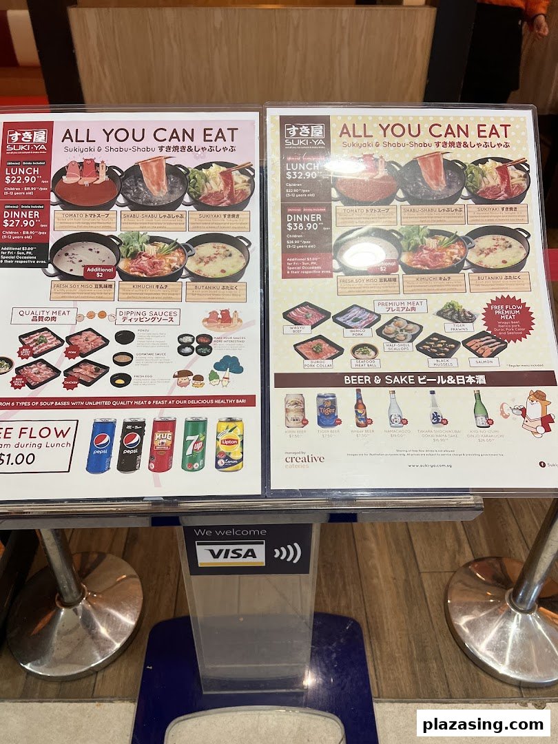 Two large menu boards displaying all-you-can-eat shabu-shabu and sukiyaki options with prices and food items.