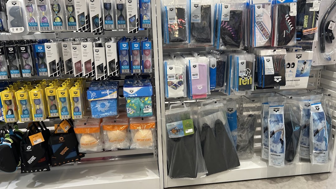 Shelves displaying a wide range of swimming accessories, including goggles, caps, and training aids.