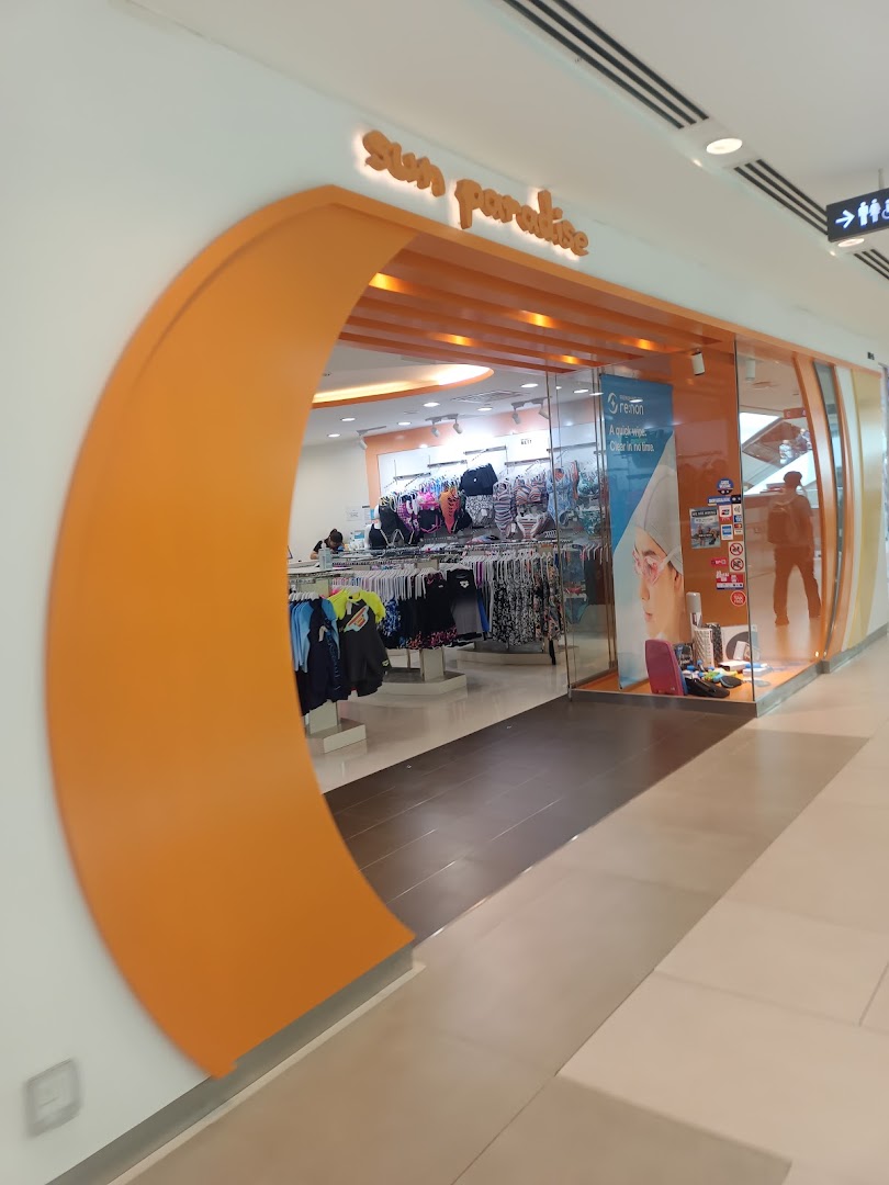 The vibrant orange entrance of Sun Paradise, a swimwear and beachwear store, in a mall.