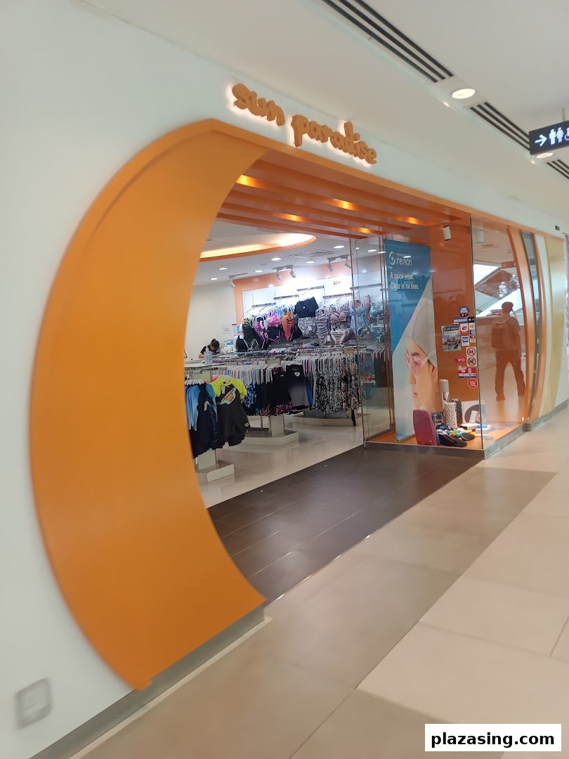 The vibrant orange entrance of Sun Paradise, a swimwear and beachwear store, in a mall.