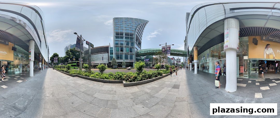 A panoramic view of a vibrant urban street with modern buildings, pedestrians, and retail shopfronts.