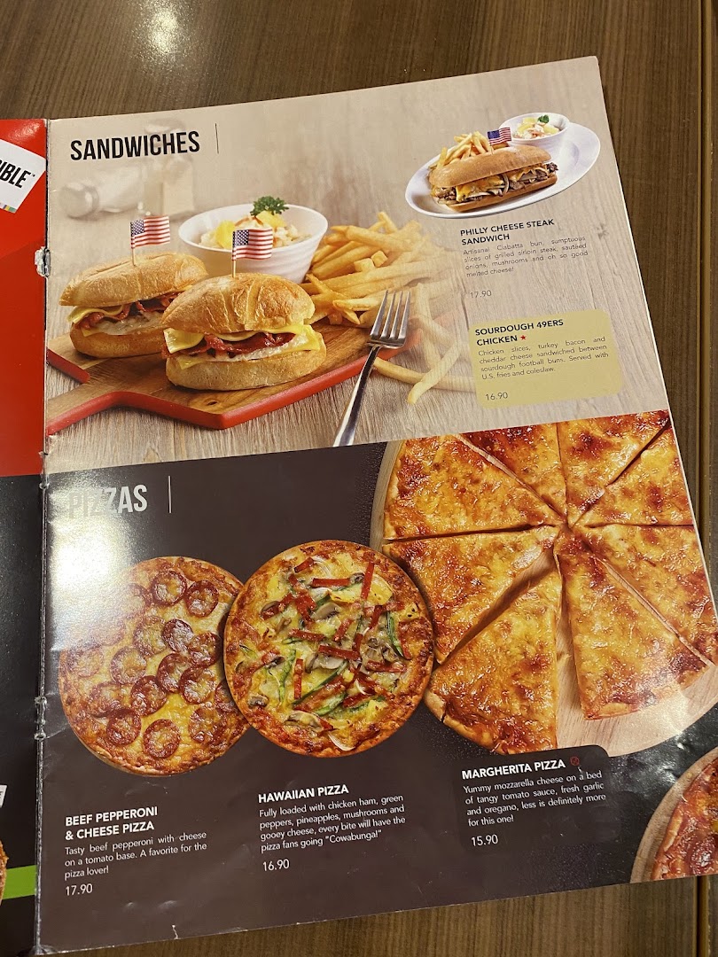 A close-up of Swensen's menu featuring sandwiches and pizzas with descriptions and prices.