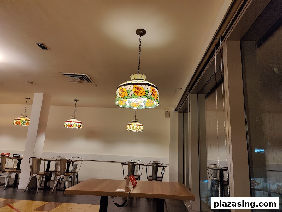 Interior view of Swensen's restaurant, featuring vintage-style stained glass pendant lamps and dining tables.