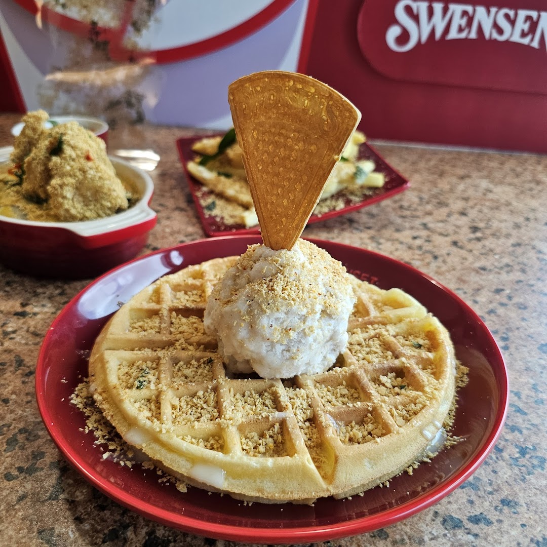 A delicious waffle topped with ice cream and crunchy bits, served on a red plate at Swensen's.