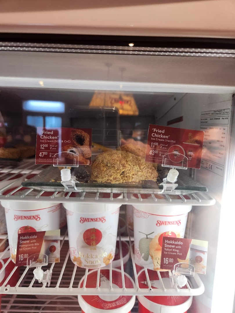 A Swensen's display freezer showcasing 'Fried Chicken' and 'Hokkaido Snow' ice cream pints with prices.