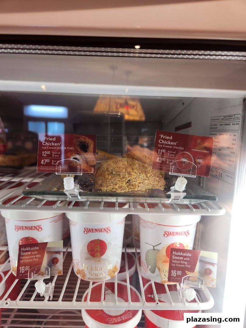 A Swensen's display freezer showcasing 'Fried Chicken' and 'Hokkaido Snow' ice cream pints with prices.