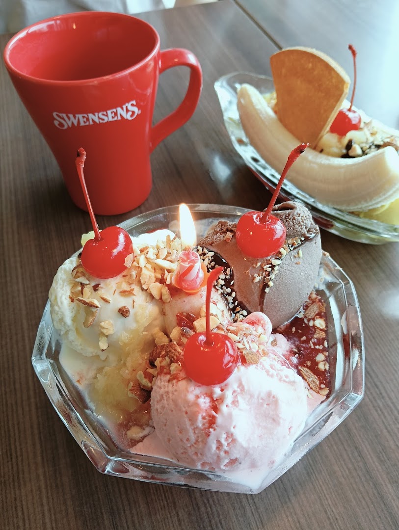 A vibrant close-up of two delicious ice cream sundaes, including a banana split, and a Swensen's branded mug.