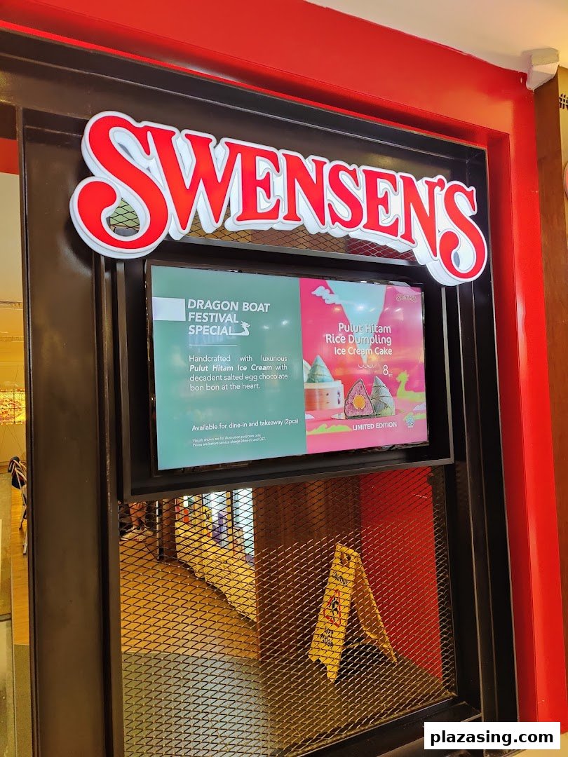 The illuminated entrance of Swensen's at Plaza Singapura, featuring its prominent sign and a digital promotional display.