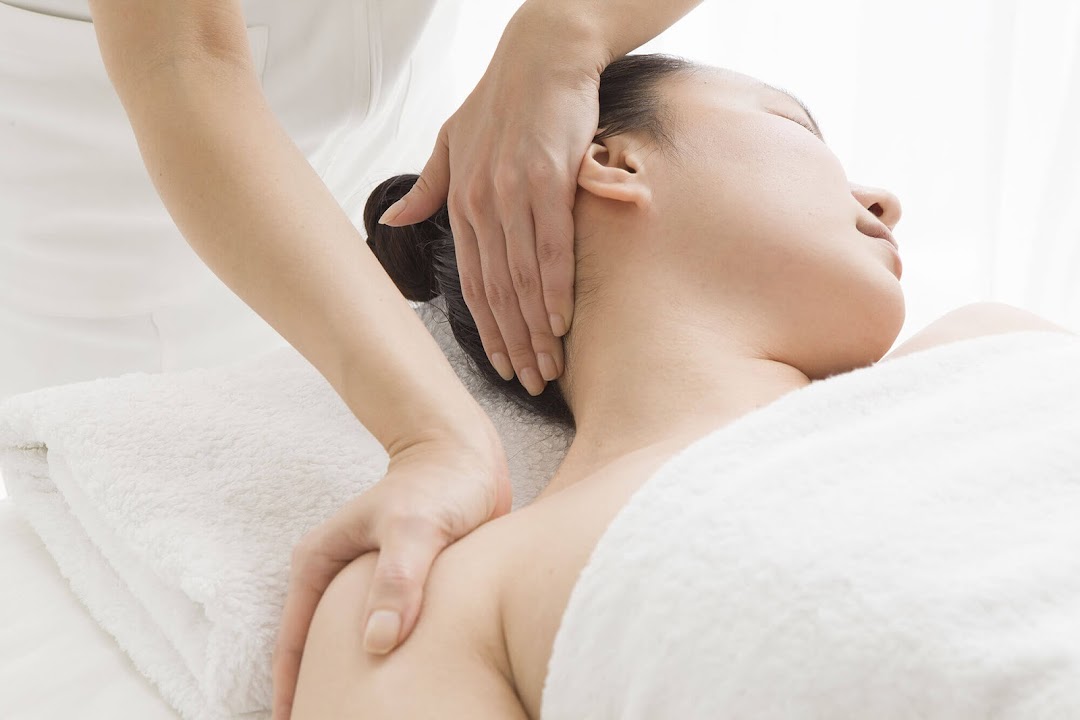 A person receiving a relaxing neck and shoulder massage at a spa.
