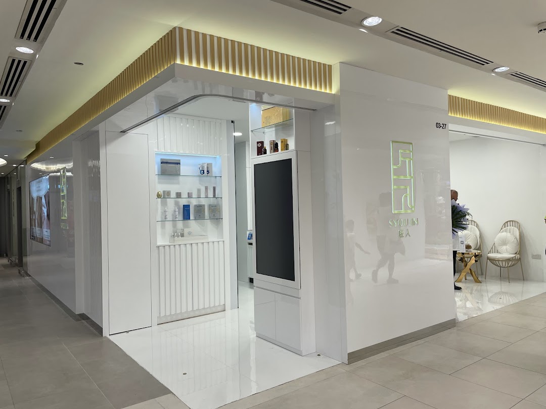 The sleek, modern white facade of Syoujin 匠人 beauty and wellness shop with its illuminated logo.