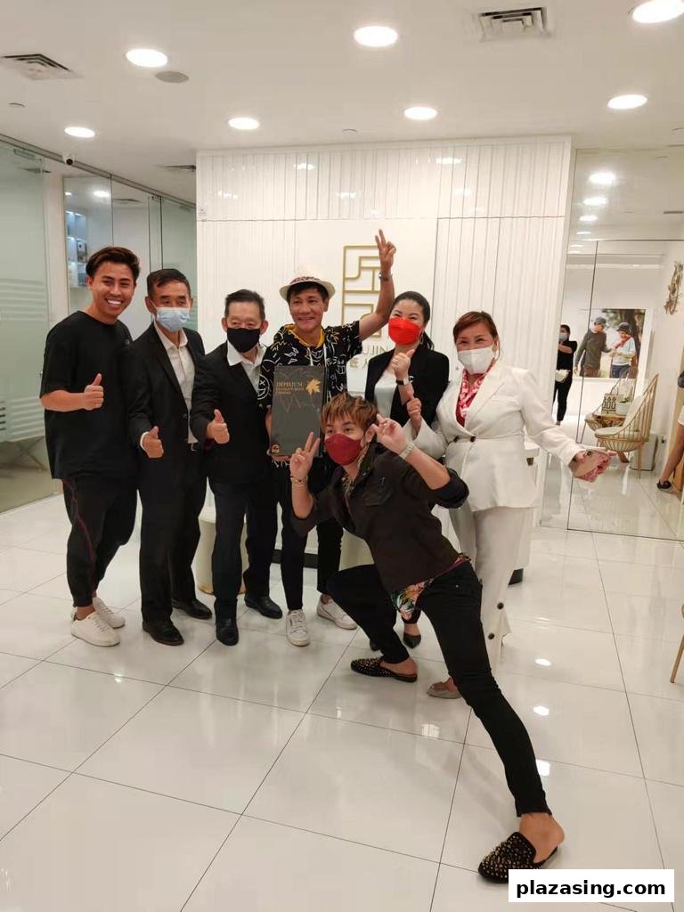 A group of cheerful individuals, some masked, posing inside the brightly lit Syoujin retail space.