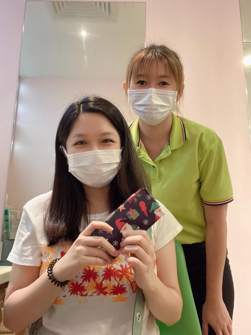 A happy customer holds a festive gift while a friendly staff member smiles in the background.
