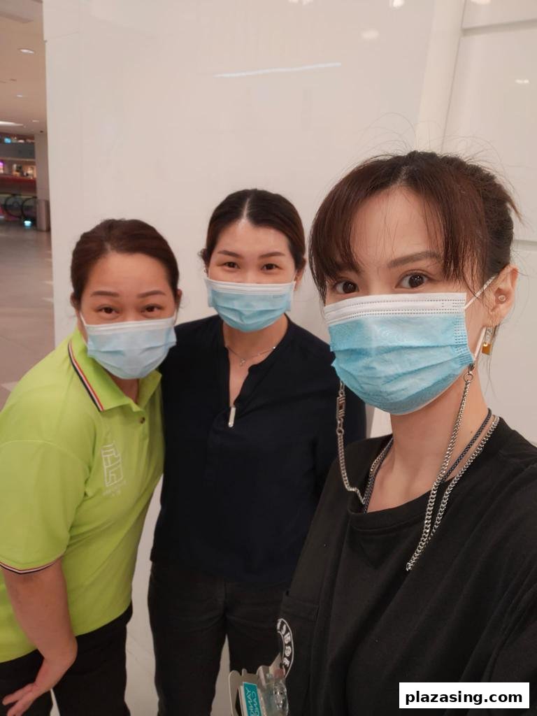 Three individuals, including a staff member in uniform, wearing masks and posing for a photo.