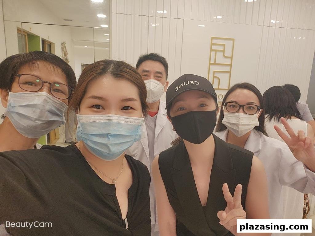 A group of masked staff and customers smiling for a selfie inside Syoujin 匠人.