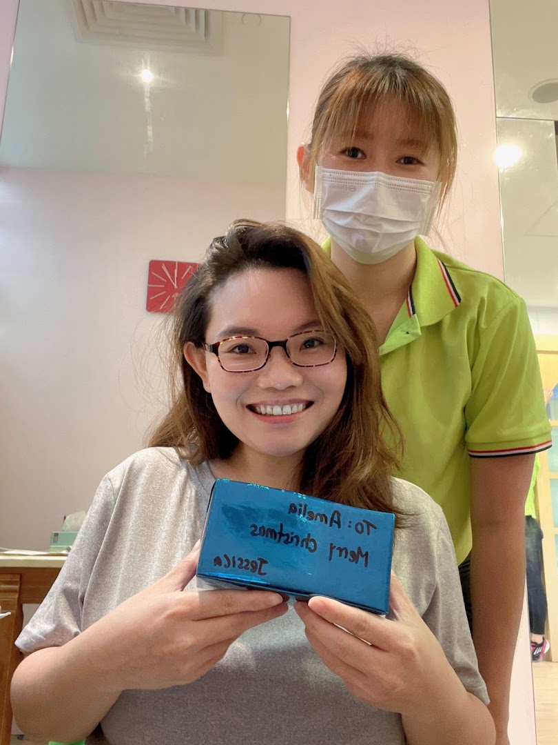A happy customer receives a gift from a friendly staff member inside the shop.