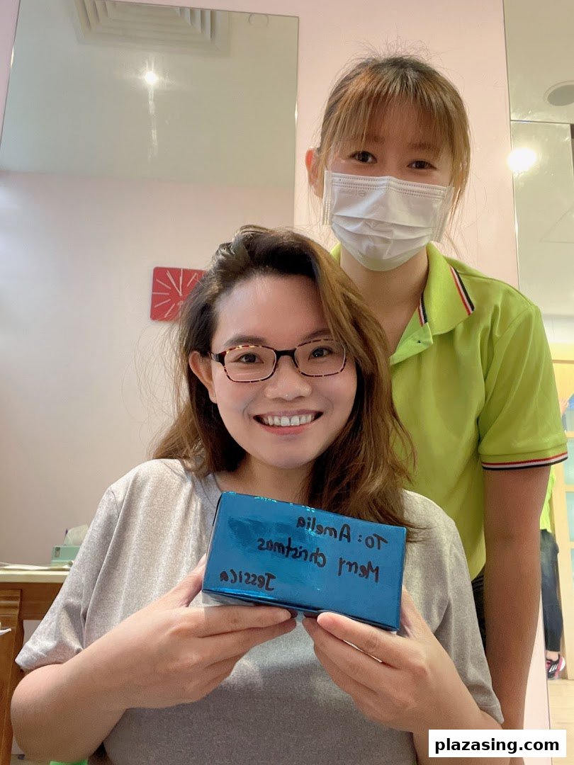 A happy customer receives a gift from a friendly staff member inside the shop.