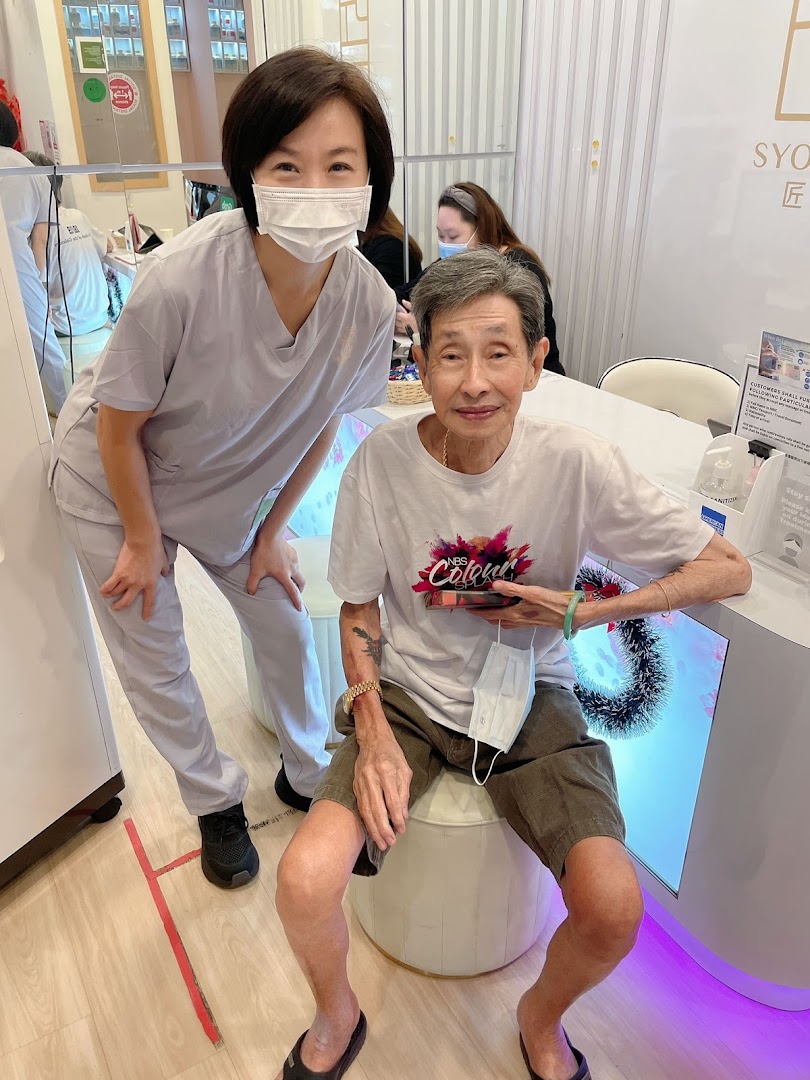 A friendly staff member poses with a happy elderly customer inside Syoujin 匠人.