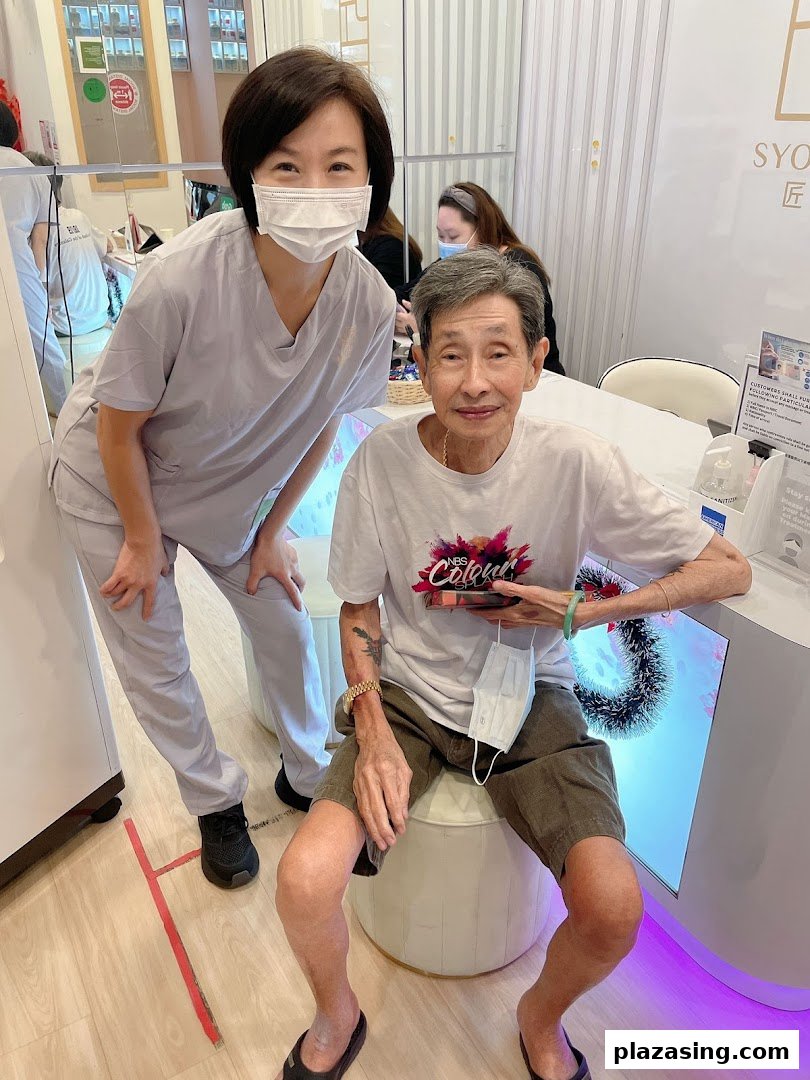 A friendly staff member poses with a happy elderly customer inside Syoujin 匠人.