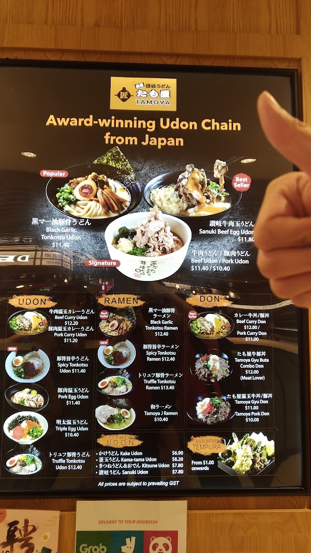 A vibrant menu board for Tamoya Udon, showcasing various udon, ramen, don, and tempura dishes with prices.