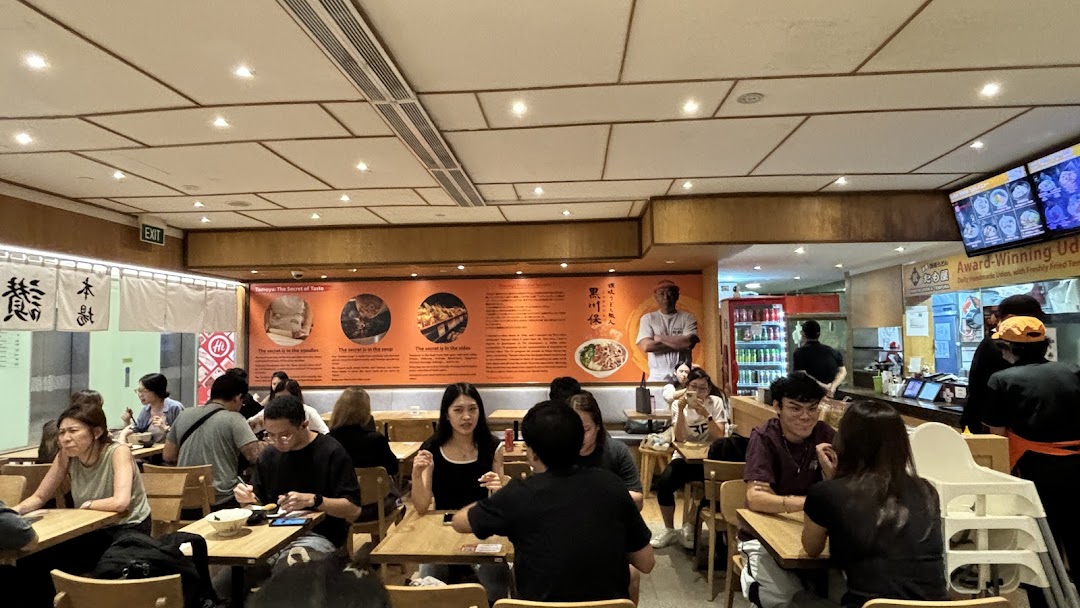 Diners enjoying meals in the bustling interior of Tamoya Udon & Tempura restaurant.