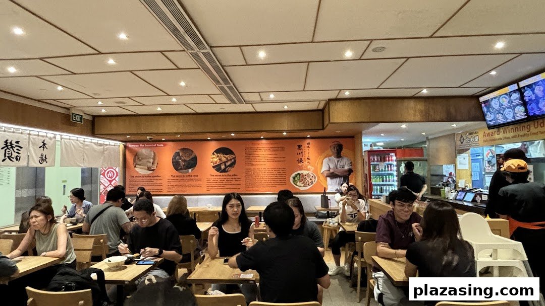 Diners enjoying meals in the bustling interior of Tamoya Udon & Tempura restaurant.